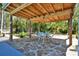 Charming covered patio with stone floor, wood ceiling, ceiling fan, and backyard views at 245 Country Circle E Dr, Port Orange, FL 32128