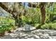 Outdoor patio area shaded by mature trees and tropical foliage offers a relaxing space to relax or dine at 245 Country Circle E Dr, Port Orange, FL 32128