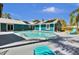 Backyard view of a pool, house, and patio with teal outdoor chairs at 245 Country Circle E Dr, Port Orange, FL 32128