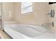 Clean and modern bathtub with a neutral tile surround and minimalist faucet fixtures at 2608 Roadster Ln, Kissimmee, FL 34746