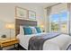This bedroom features a large window, sleek headboard, and two side tables with lamps at 2608 Roadster Ln, Kissimmee, FL 34746