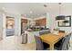 Well-lit kitchen with stainless steel appliances, wood cabinets, granite counters, and a dining table at 2608 Roadster Ln, Kissimmee, FL 34746