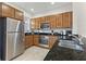 Well-equipped kitchen featuring stainless appliances, granite countertops, and wood cabinets at 2608 Roadster Ln, Kissimmee, FL 34746