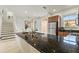 Granite kitchen island showing stainless refrigerator and tile flooring, with access to the stairs at 2608 Roadster Ln, Kissimmee, FL 34746