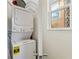 Efficient laundry space with stacked washer and dryer next to a bright window at 2608 Roadster Ln, Kissimmee, FL 34746