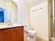 Bright bathroom features a wood vanity, white toilet and a glass enclosed shower at 2651 Andros Ln, Kissimmee, FL 34747