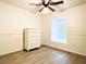 Neutral bedroom featuring wood-look floors, and a large window with pleated shades at 2651 Andros Ln, Kissimmee, FL 34747