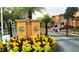 Community entrance gate with decorative pillars and vibrant flower beds for added curb appeal at 2651 Andros Ln, Kissimmee, FL 34747