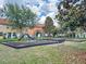 Community playground with slides and swings amidst lush greenery and blue skies at 2651 Andros Ln, Kissimmee, FL 34747