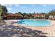 Community pool area surrounded by brick, lounge chairs, and well-maintained landscaping at 2651 Andros Ln, Kissimmee, FL 34747