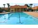 Community pool with blue water, lounge chairs, and a covered pavilion for relaxing at 2651 Andros Ln, Kissimmee, FL 34747
