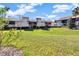 Scenic backyard view of condos with well-manicured lawn, mature trees, and partial views of the building's exterior at 3012 S Semoran Blvd # 3, Orlando, FL 32822