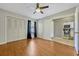 Spacious bedroom with wood floors, ceiling fan, and closet, adjacent to kitchen area at 3012 S Semoran Blvd # 3, Orlando, FL 32822