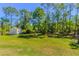 Spacious backyard with lush greenery, a storage shed, and mature trees for added privacy at 3394 Hawkin Dr, Kissimmee, FL 34746