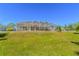Exterior view of the home featuring a large backyard and screened-in pool at 3394 Hawkin Dr, Kissimmee, FL 34746