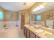 Bathroom showcasing double sinks, a soaking tub, and a separate glass-enclosed shower at 3394 Hawkin Dr, Kissimmee, FL 34746