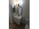 Well-lit bathroom featuring a modern vanity with new fixtures, stylish mirror, and tiled floors at 3504 Portersfield Rd, Orlando, FL 32808