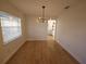 Bright dining room featuring hardwood floors, modern light fixture, large window, and plenty of space at 3504 Portersfield Rd, Orlando, FL 32808