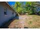 Side yard showcasing potential for outdoor living and gardening, surrounded by greenery and a home exterior view at 4121 Caywood Cir, Orlando, FL 32810