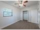 The bedroom includes a window, carpeted floor, ceiling fan, and closet for optimal functionality at 4121 Caywood Cir, Orlando, FL 32810