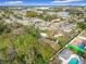 Scenic aerial perspective of a neighborhood featuring lush trees, community pools, and a tranquil lake at 444 Sunnyview Cir, Orlando, FL 32810