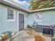 Rear exterior view showcasing the home's entrance, window, and outdoor area, with space for outdoor seating at 444 Sunnyview Cir, Orlando, FL 32810