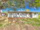 The back exterior features multiple windows with bars, access door, and a well-manicured lawn with scattered leaves at 444 Sunnyview Cir, Orlando, FL 32810