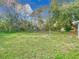 Expansive backyard featuring lush green lawn and mature trees, ideal for outdoor activities at 444 Sunnyview Cir, Orlando, FL 32810