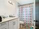 Well-lit bathroom featuring a functional vanity and a shower with a patterned curtain at 444 Sunnyview Cir, Orlando, FL 32810