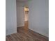 Bright bedroom featuring wood-look floors, white walls and trim, and view into an adjacent room at 444 Sunnyview Cir, Orlando, FL 32810