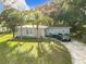 Charming single-story home with lush front lawn, palm trees, and driveway at 444 Sunnyview Cir, Orlando, FL 32810