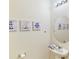 Elegant powder room with stylish nautical decor, pedestal sink and framed round mirror at 4512 Sparkling Shell Ave, Kissimmee, FL 34746