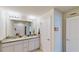 Bright bathroom featuring a double vanity with granite countertop, framed mirror, and a separate toilet room at 4512 Sparkling Shell Ave, Kissimmee, FL 34746