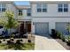 Charming townhouse featuring a gray exterior, well-manicured lawn and a two-car garage at 4512 Sparkling Shell Ave, Kissimmee, FL 34746