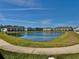 Scenic view of a community pond reflecting homes under a blue sky at 4512 Sparkling Shell Ave, Kissimmee, FL 34746