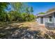 Large backyard featuring a side door to the home with some lawn chairs at 5206 Cortez Dr, Orlando, FL 32808