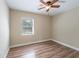 Bright bedroom with wood-look floors and natural light from a window at 5206 Cortez Dr, Orlando, FL 32808