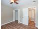 Bright bedroom with wood-look flooring, ceiling fan, closet, and doorway to another room at 5206 Cortez Dr, Orlando, FL 32808