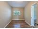 Cozy bedroom with wood-look floors, neutral walls, and a bright window view at 5206 Cortez Dr, Orlando, FL 32808