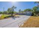 Charming single-story home with a spacious front yard and a long concrete driveway under a bright blue sky at 5206 Cortez Dr, Orlando, FL 32808