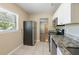 Updated kitchen featuring granite counters, stainless appliances, white cabinets, tile floors, and natural light at 5206 Cortez Dr, Orlando, FL 32808