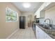 Bright kitchen featuring granite counters, stainless appliances, white cabinets, tile floors, and natural light at 5206 Cortez Dr, Orlando, FL 32808