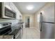 Modern kitchen featuring stainless steel appliances, granite countertops, white cabinets, and tile flooring at 5206 Cortez Dr, Orlando, FL 32808