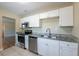 Updated kitchen featuring stainless steel appliances, granite countertops, white cabinetry, and tile flooring at 5206 Cortez Dr, Orlando, FL 32808