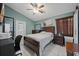 Serene bedroom featuring a wooden dresser, a warm ceiling fan, and soft, natural lighting at 536 Southern Charm Dr, Orlando, FL 32807