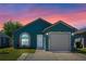 Charming home featuring a garage and well-maintained lawn, with a beautiful sunset sky in the background at 536 Southern Charm Dr, Orlando, FL 32807