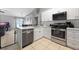 Open kitchen showcases a stainless steel dishwasher, range, and white cabinets with a seamless design at 536 Southern Charm Dr, Orlando, FL 32807