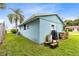 Exterior view of the home with trashcans, an air conditioning unit, and a grassy yard at 6305 Bass Hwy, St Cloud, FL 34771