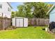 Backyard featuring a white storage shed, grassy lawn, and a wooden fence at 6305 Bass Hwy, St Cloud, FL 34771