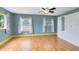 This bedroom features beautiful wood floors, blue painted walls, and natural light from the two large windows at 6305 Bass Hwy, St Cloud, FL 34771